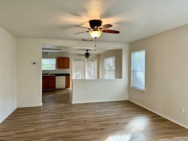 unfurnished living room with a textured ceiling, dark hardwood / wood-style floors, ceiling fan, and sink