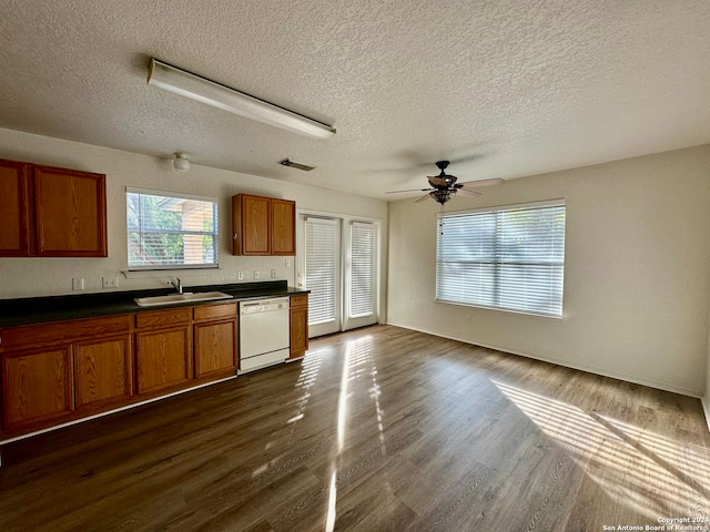 kitchen with a textured ceiling, ceiling fan, sink, dishwasher, and dark hardwood / wood-style floors