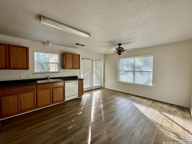330 Agency Oaks, San Antonio, TX 78249 - kitchen featuring white dishwasher, a sink, brown cabinetry, dark countertops, and a textured ceiling