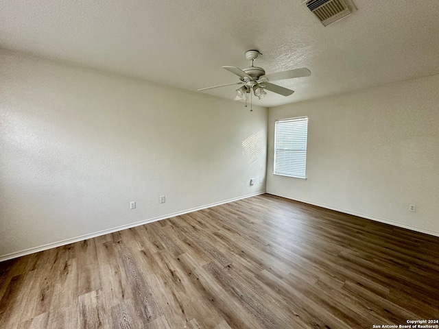 empty room featuring a textured ceiling, light hardwood / wood-style flooring, and ceiling fan