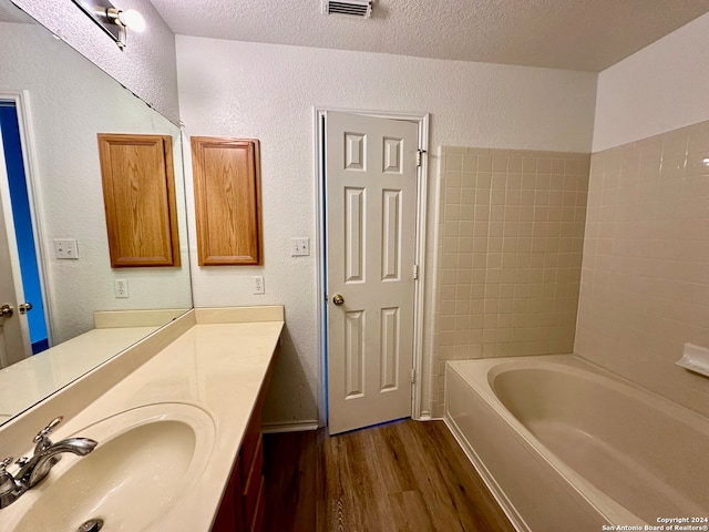 bathroom featuring vanity, wood-type flooring, and a textured ceiling