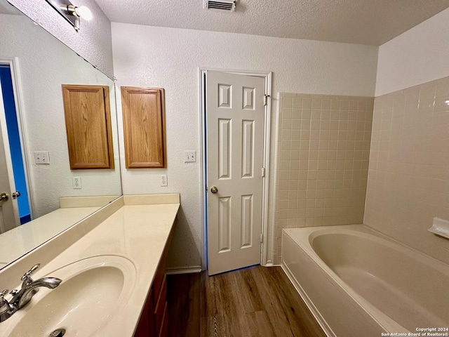330 Agency Oaks, San Antonio, TX 78249 - bathroom featuring wood finished floors, a textured ceiling, vanity, and a textured wall