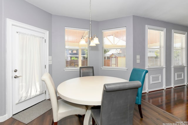 dining room featuring dark hardwood / wood-style floors and an inviting chandelier