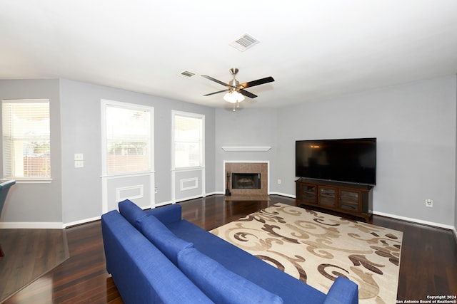 living room with ceiling fan, a fireplace, and dark hardwood / wood-style floors