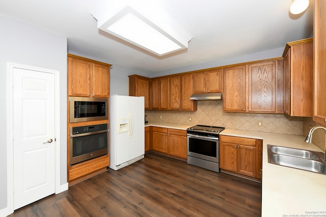 kitchen with backsplash, sink, dark wood-type flooring, and appliances with stainless steel finishes