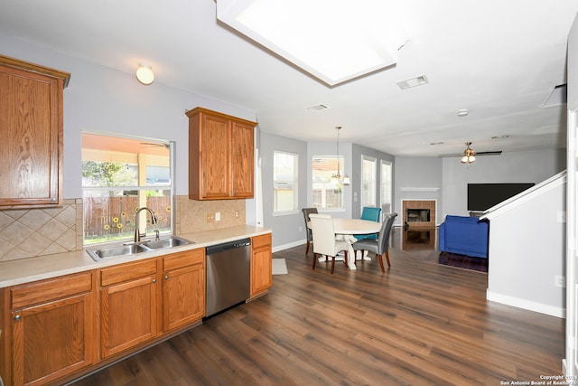 kitchen with stainless steel dishwasher, dark hardwood / wood-style flooring, sink, and a wealth of natural light