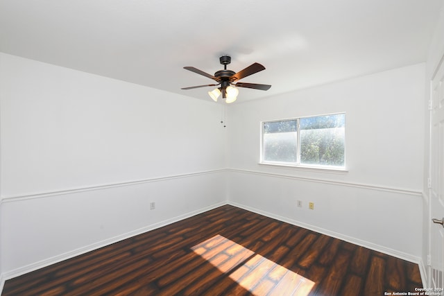 empty room with ceiling fan and dark hardwood / wood-style flooring