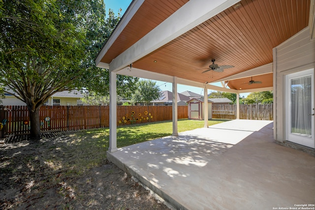 view of patio featuring ceiling fan and a shed