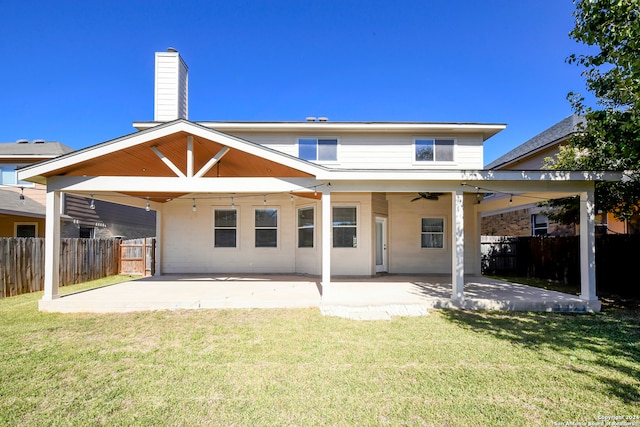 rear view of house featuring ceiling fan, a yard, and a patio