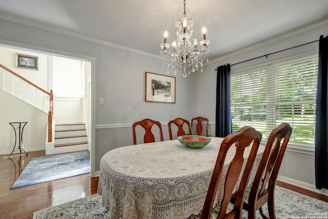 dining room with hardwood / wood-style floors, a notable chandelier, and ornamental molding