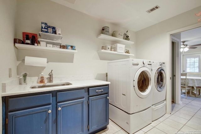 clothes washing area with ceiling fan, sink, cabinets, light tile patterned floors, and washer and dryer