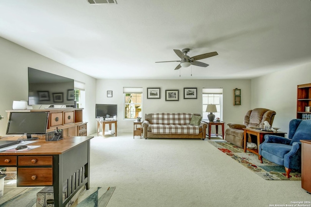 carpeted living room with ceiling fan and a healthy amount of sunlight