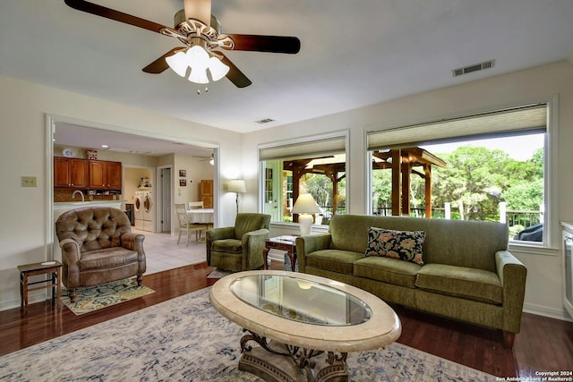 living room featuring ceiling fan, french doors, washer and dryer, and hardwood / wood-style flooring