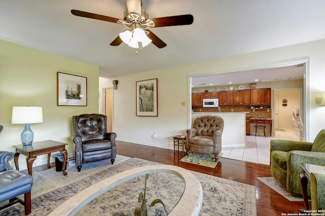 living room with ceiling fan and light hardwood / wood-style flooring