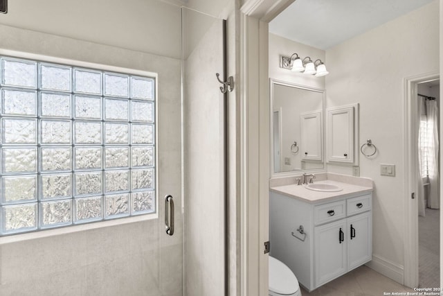 bathroom with vanity, a wealth of natural light, tile patterned floors, and toilet