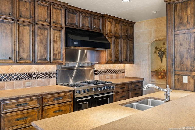 kitchen featuring range with two ovens, ventilation hood, and sink