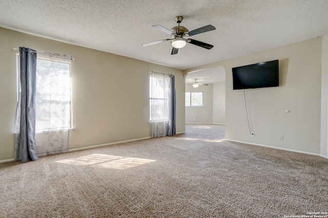 carpeted spare room with a textured ceiling and ceiling fan