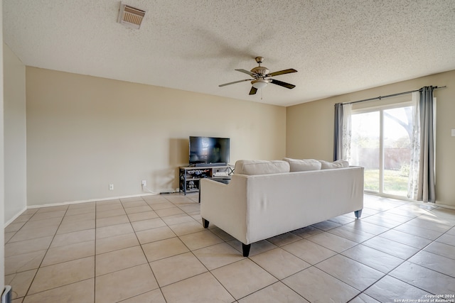 unfurnished living room featuring ceiling fan, light tile patterned flooring, and a textured ceiling