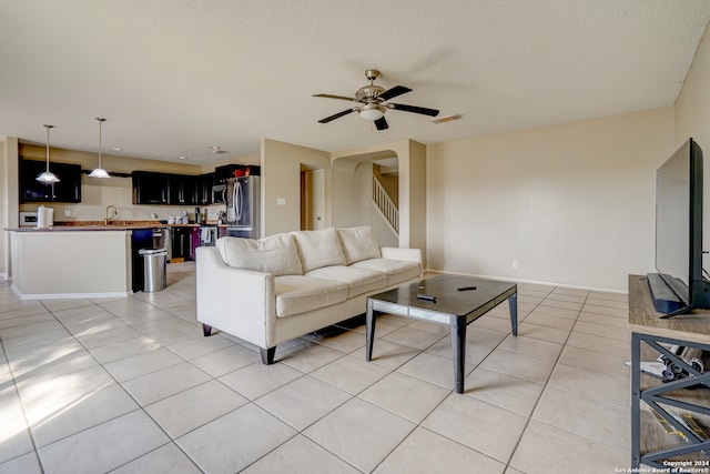 tiled living room featuring ceiling fan and a textured ceiling