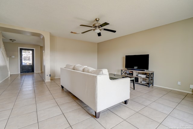 living room with ceiling fan, light tile patterned floors, and a textured ceiling