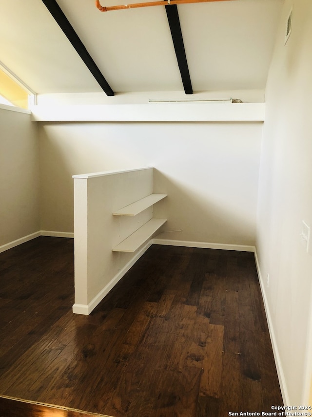 interior space with beam ceiling and dark wood-type flooring