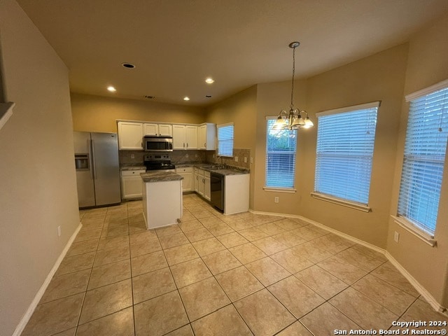 kitchen featuring backsplash, black appliances, pendant lighting, light tile patterned floors, and white cabinetry