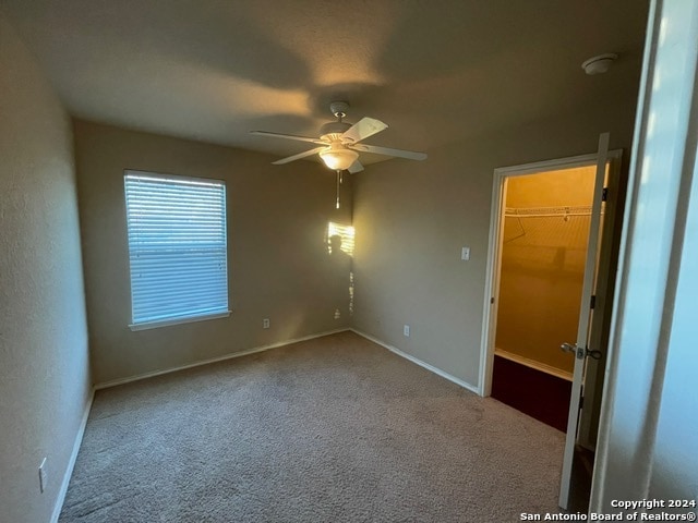 empty room with ceiling fan and light colored carpet