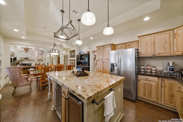 kitchen featuring stainless steel fridge, a center island, dark wood-type flooring, and pendant lighting