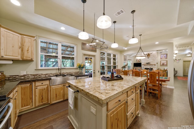 kitchen with a kitchen island, hanging light fixtures, dark wood-type flooring, and stainless steel range oven