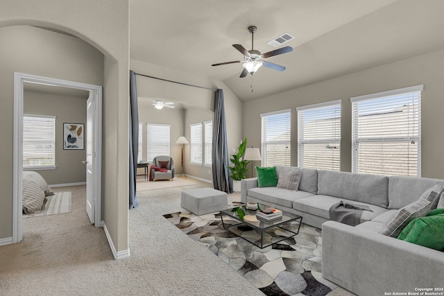 living room with ceiling fan, light colored carpet, and vaulted ceiling