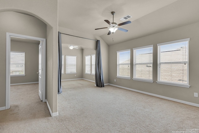 carpeted spare room with vaulted ceiling, plenty of natural light, and ceiling fan