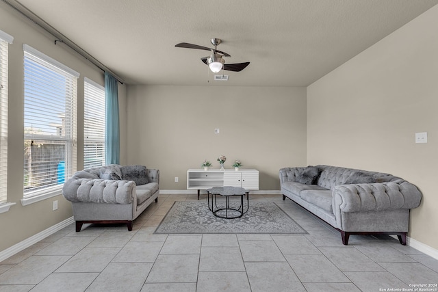 tiled living room with ceiling fan and a textured ceiling