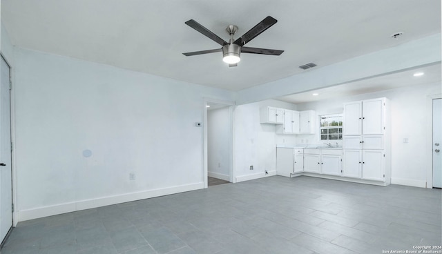 unfurnished living room with ceiling fan and sink