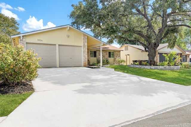 ranch-style home featuring a garage and a front lawn