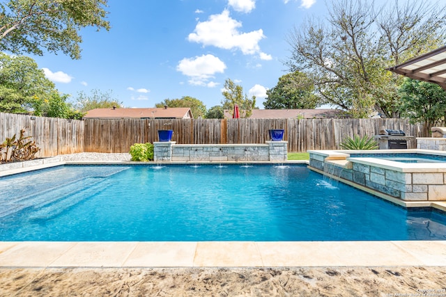 view of pool featuring area for grilling, pool water feature, and an in ground hot tub