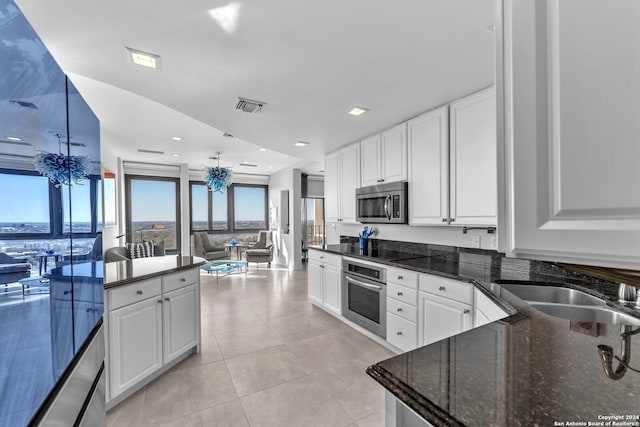 kitchen with dark stone countertops, white cabinetry, and appliances with stainless steel finishes