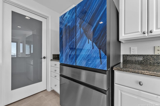 kitchen featuring dark stone countertops, white cabinetry, and light tile patterned floors