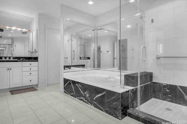 bathroom featuring plus walk in shower, vanity, and tile patterned flooring