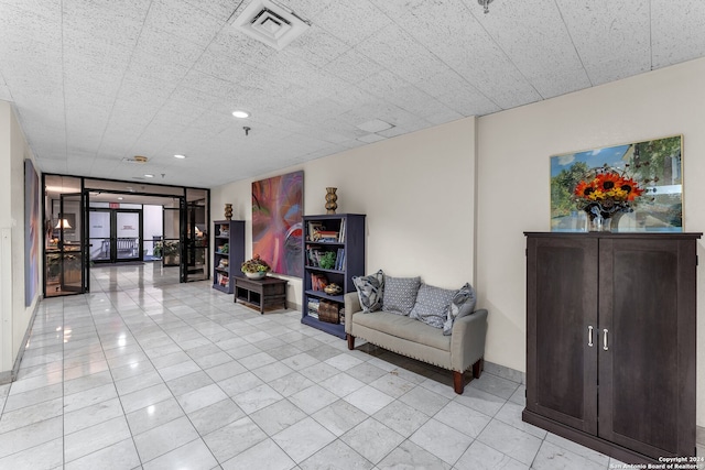 sitting room with french doors and light tile patterned flooring