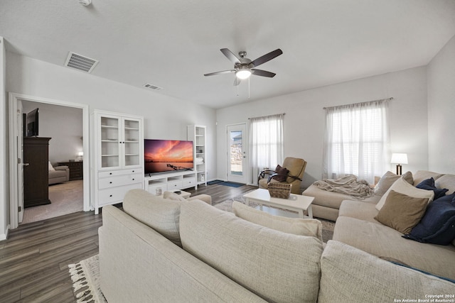 living room featuring ceiling fan and dark wood-type flooring