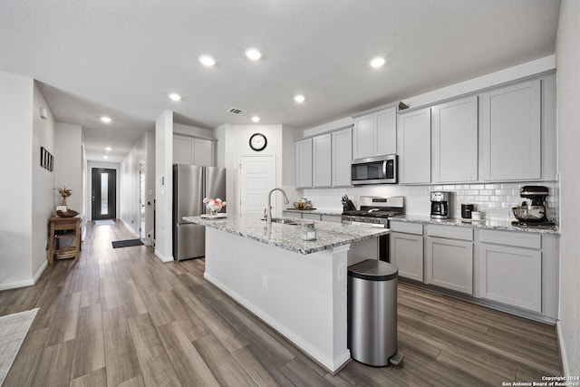 kitchen featuring light stone countertops, sink, dark hardwood / wood-style floors, and appliances with stainless steel finishes