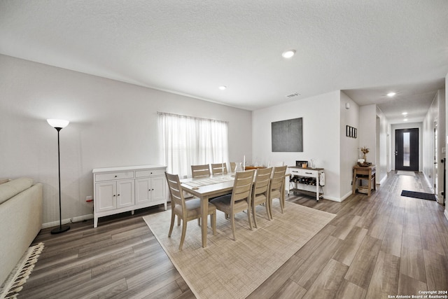 dining area featuring hardwood / wood-style flooring and a textured ceiling