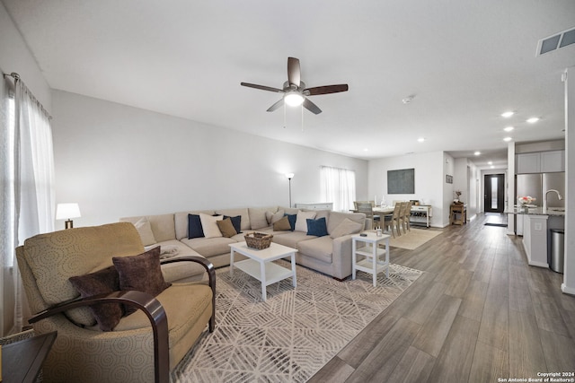 living room featuring light wood-type flooring and ceiling fan