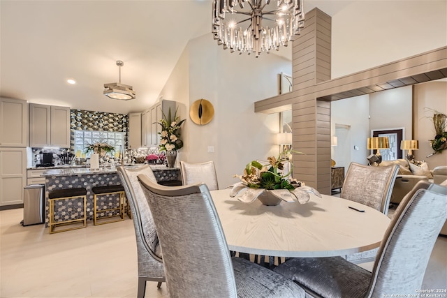 dining space featuring a towering ceiling and a notable chandelier