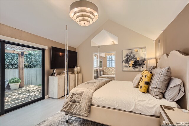 bedroom with access to exterior, light hardwood / wood-style floors, and lofted ceiling