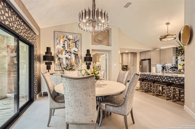 dining area with a chandelier and high vaulted ceiling