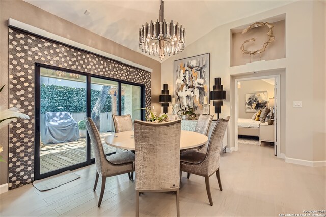 dining room featuring a chandelier, lofted ceiling, and light hardwood / wood-style floors