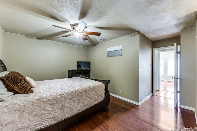 bedroom featuring a textured ceiling, ceiling fan, and dark wood-type flooring