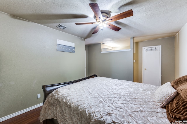 bedroom featuring hardwood / wood-style floors, ceiling fan, and a textured ceiling