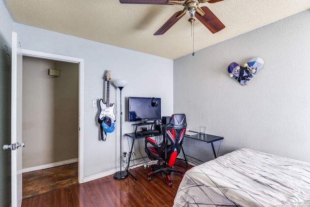 bedroom with a textured ceiling, ceiling fan, and dark hardwood / wood-style floors